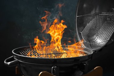 Koyu arka planda yanan ateş ile Modern barbekü ızgara