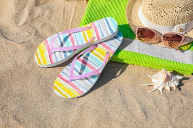 Kum üzerinde şık plaj aksesuarları ile ayarlayın, görünümün üzerinde