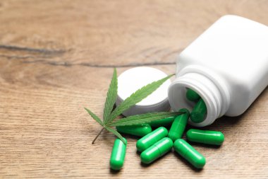 Kenevir yaprağı ve şişe ahşap masa üzerinde kapsül ile. Metin için alan