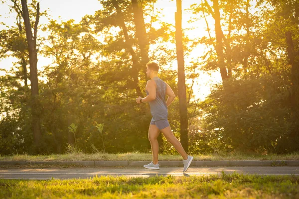 Giovane che corre nel parco nella giornata di sole — Foto Stock