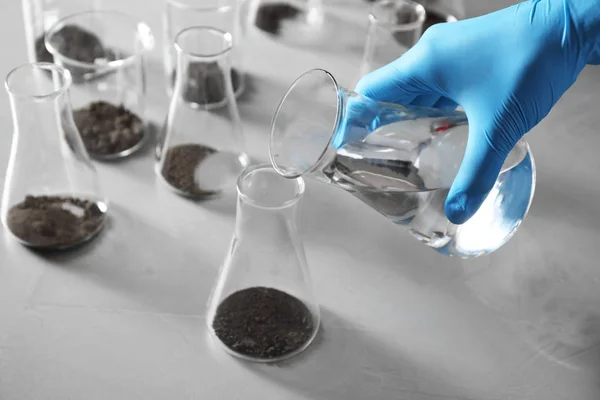 Wetenschapper voorbereiding bodem extract aan tafel, close-up. Laboratoriumonderzoek — Stockfoto