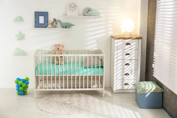 可爱的苗圃内部与舒适的婴儿床靠近白色墙壁 — 图库照片
