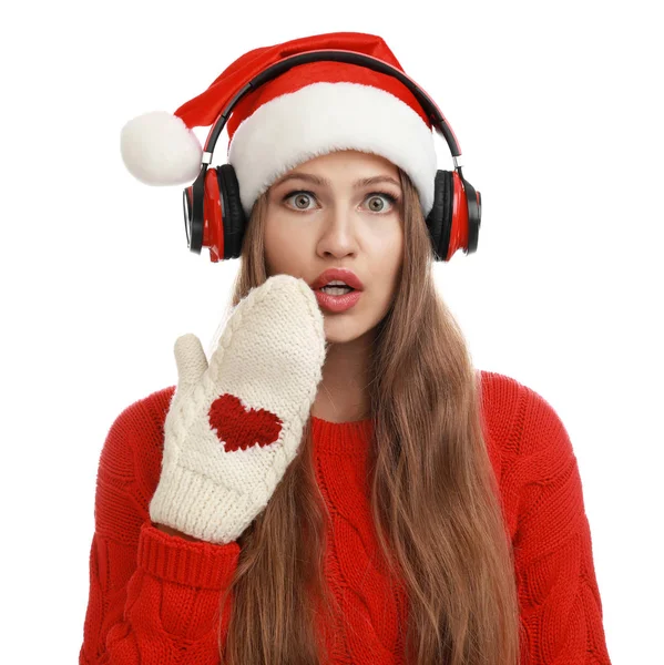 Jonge vrouw in Santa hoed luisteren naar kerst muziek op witte achtergrond — Stockfoto