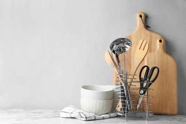 Different kitchen utensils on table against light background. Space for text — Stock Photo, Image