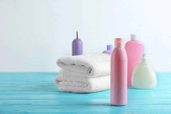 Toiletries and folded towels on light blue wooden table — Stock Photo, Image