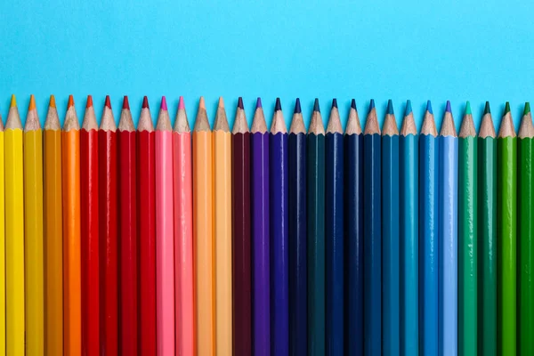 Lápices de colores sobre fondo azul claro, planas — Foto de Stock