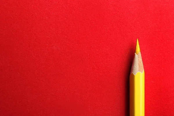 Жовтий олівець на червоному тлі. Простір для тексту — стокове фото