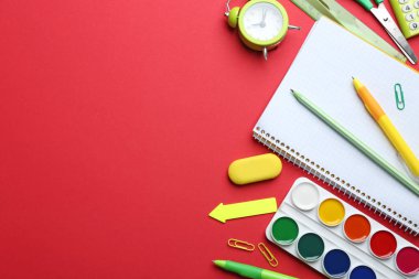 Kırmızı arka plan üzerinde parlak okul kırtasiye, düz yatıyordu. Metin için alan