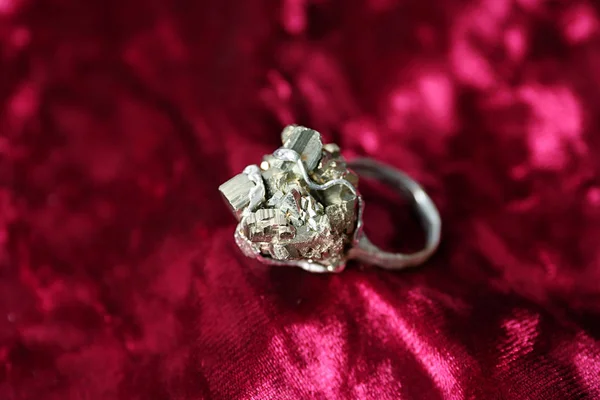 Красиве срібне кільце з піритовими дорогоцінними каменями на бордовій тканині, крупним планом — стокове фото