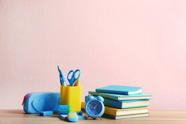 不同学校文具在木桌上与粉红色背景。文本空间 — 图库照片