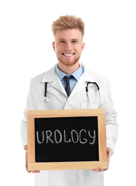 Homme médecin tenant petit tableau noir avec mot UROLOGIE sur fond blanc — Photo