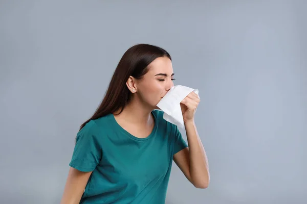 Young woman suffering from allergy on grey background — Stock Photo, Image