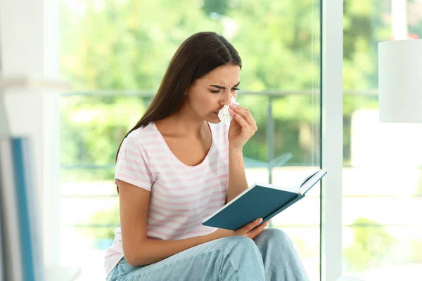 Femeia tânără cu carte care suferă de alergie acasă — Fotografie, imagine de stoc