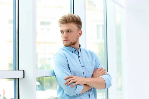 Retrato de belo jovem olhando para fora janela dentro de casa — Fotografia de Stock