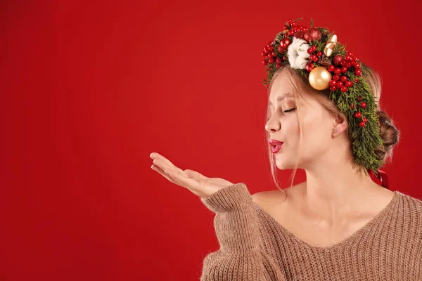 Όμορφη νεαρή γυναίκα που φοράει Χριστουγεννιάτικο στεφάνι σε κόκκινο φόντο. Χώρος για κείμενο — Φωτογραφία Αρχείου