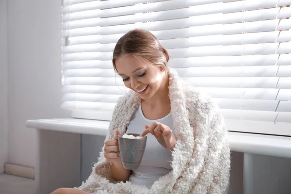 집에서 창 근처 뜨거운 음료와 마시멜로 의 컵 아름 다운 젊은 여자. 겨울 분위기 — 스톡 사진
