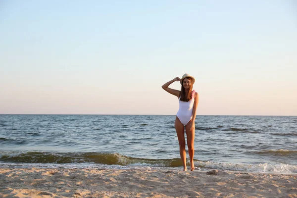 Belle jeune femme sur la plage de sable fin près de la mer — Photo