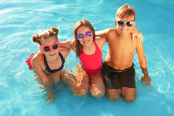Niños felices con gafas de sol en la piscina — Foto de Stock