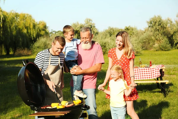 Familie fericită cu grătar în parc în ziua însorită — Fotografie, imagine de stoc
