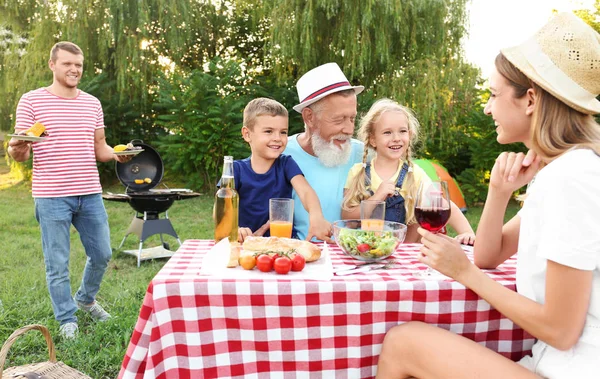 Familie fericită cu grătar în parc în ziua însorită — Fotografie, imagine de stoc