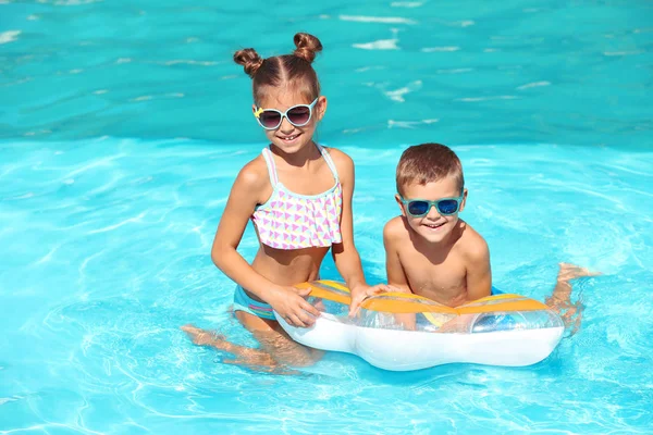 Lindos niños pequeños con anillo inflable en la piscina — Foto de Stock