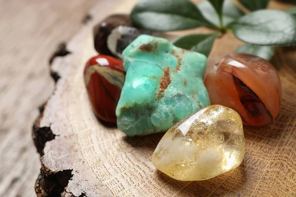 Cuarzo citrino y hermosas piedras preciosas en soporte de madera, primer plano — Foto de Stock