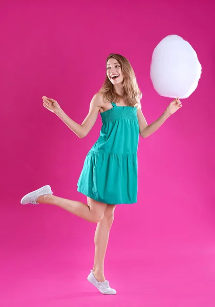 Pembe arka plan üzerinde pamuk şeker ile Mutlu genç kadın — Stok fotoğraf