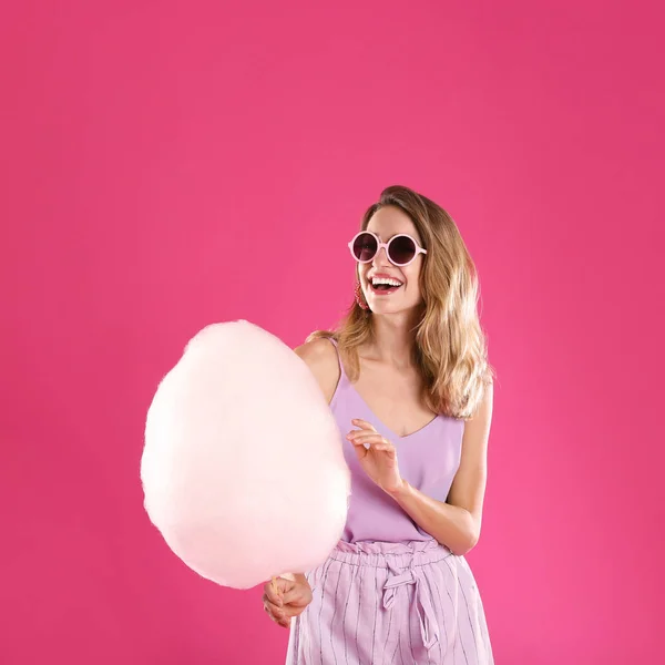 Pembe arka plan üzerinde pamuk şeker ile Mutlu genç kadın — Stok fotoğraf
