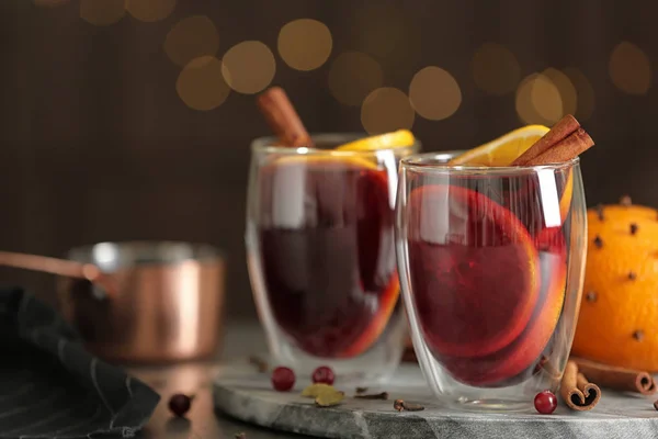 Verres de vin chaud savoureux sur la table contre les lumières festives — Photo