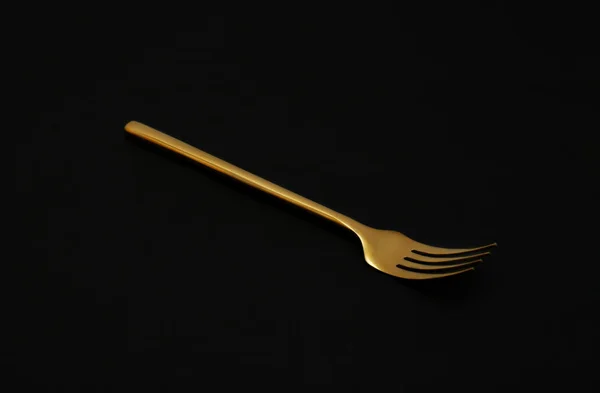 Brillante tenedor de oro elegante sobre fondo negro — Foto de Stock