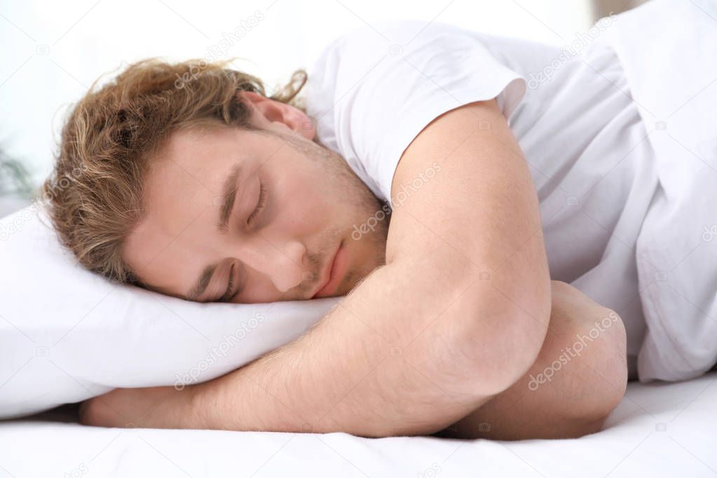 Handsome young man sleeping on pillow at home. Bedtime