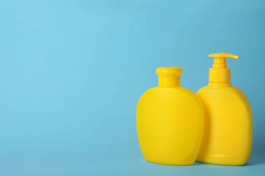 Açık mavi arka plan üzerinde saç bakım kozmetik ile Şişeler