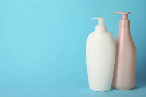Botellas con cosméticos para el cuidado del cabello sobre fondo azul claro —  Fotos de Stock