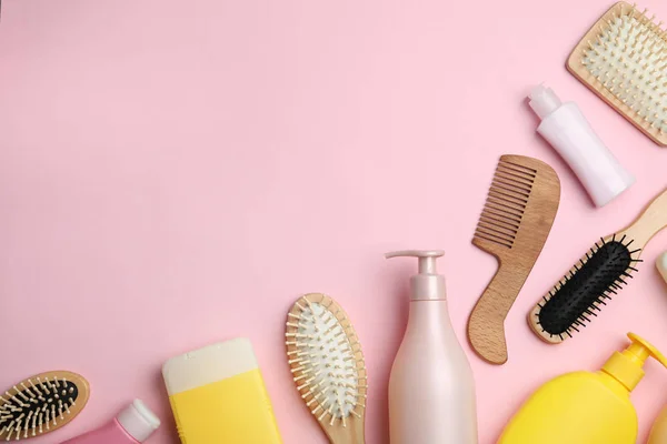 Płaska kompozycja z produktami kosmetycznymi do włosów i narzędziami na różowym tle. Miejsce na tekst — Zdjęcie stockowe