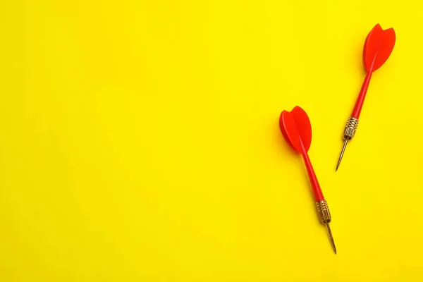 Setas de dardo vermelho no fundo amarelo, flat lay com espaço para texto — Fotografia de Stock