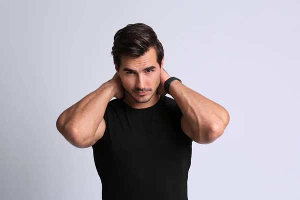 Portret przystojnego młodego mężczyzny w czarnym t-shirt na szarym tle — Zdjęcie stockowe
