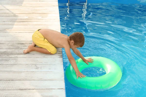 Małe dziecko docierając do nadmuchiwanego pierścienia w odkrytym basenie. Niebezpieczna sytuacja — Zdjęcie stockowe