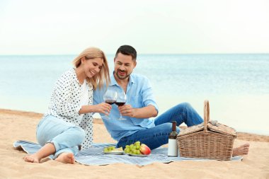 Mutlu romantik çift plajda piknik yapıyor