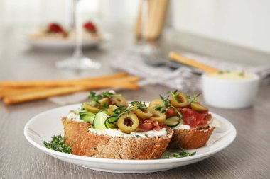 Gri ahşap masa üzerinde prosciutto ile lezzetli bruschettas Tabak