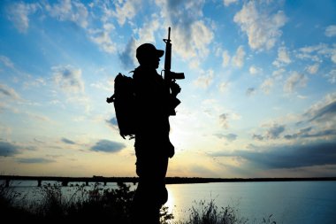 Dışarıda devriye gezen makineli tüfekli bir asker. Askerlik hizmeti