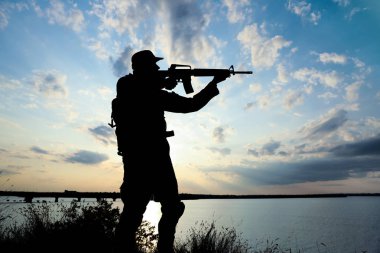 Dışarıda devriye gezen makineli tüfekli bir asker. Askerlik hizmeti