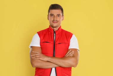 Sarı arka planda mutlu genç kurye portresi