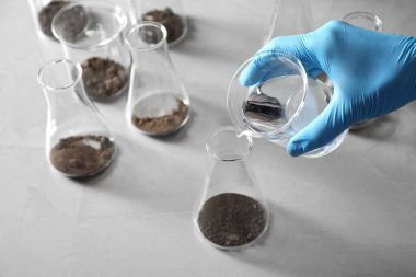 Bilim adamı masada toprak ekstresi hazırlıyor, yakın çekim. Laboratuvar araştırmaları