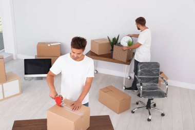 Genç işçi paketleme kutusu ve ofisteki meslektaşı. Taşıma hizmeti