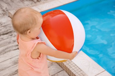 Little baby playing near outdoor swimming pool. Dangerous situation clipart