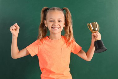Chalkboard yakınında altın kazanan fincan ile Mutlu kız