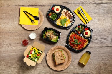 Ahşap masa üzerinde farklı yemekler ile Öğle yemeği kutuları, düz yatıyordu. Sağlıklı gıda dağıtımı