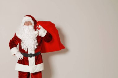 Gri arka planda hediyeler dolu çanta ile Otantik Noel Baba. Metin için alan