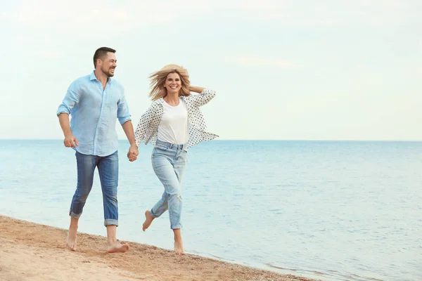 Boldog romantikus pár együtt fut a strandon, hely a szöveghez — Stock Fotó