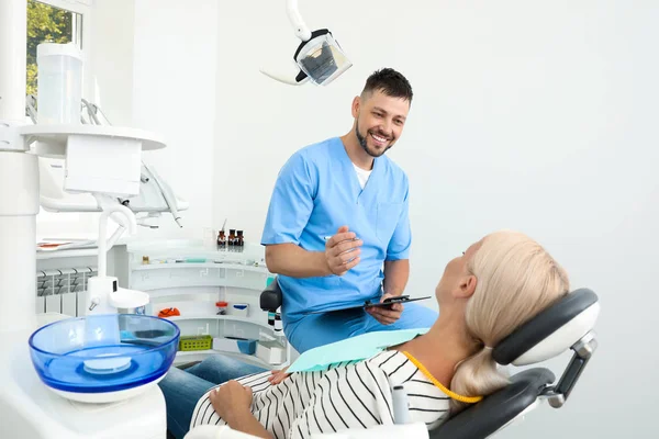 Профессиональный стоматолог, работающий с пациентом в клинике — стоковое фото